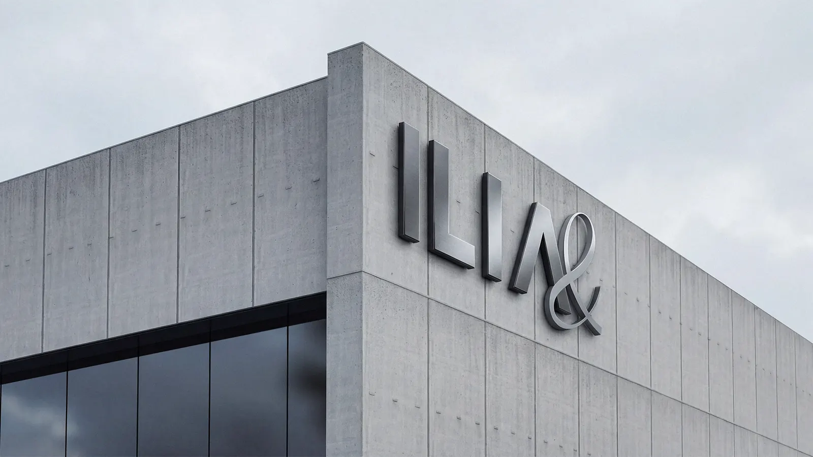 ILIA signage in brushed steel on a concrete building